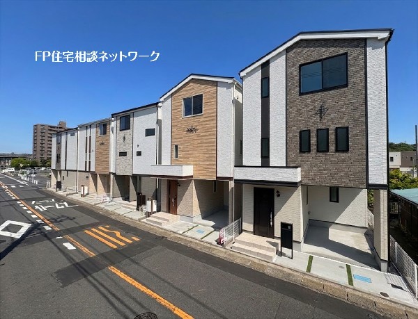外観:青空に映える、モダンで落ち着いた色合いの外観デザイン。前面道路も広く、大切な愛車を雨から守るビルトインガレージ付きの新築戸建てです。