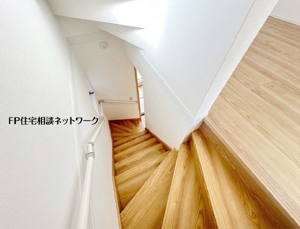 木製の踏板が温かみを感じさせる階段。上部からの視点は、開放的な空間と下階への繋がりを感じさせます。