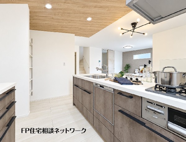 木目調の天井とこだわりの照明が、温かみのある空間を演出するキッチン。対面式で家族と会話を楽しめます。食洗機も付いており、家事もスムーズに。