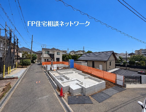 外観:青空に映える建築中の現地。道路の先まで住宅街が続き、新しい暮らしを思い描ける風景です。