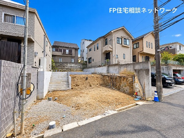 外観:青空の下、落ち着いた住宅街に広がる開放感のある敷地。周囲には戸建住宅が立ち並び、穏やかな街並みが印象的です。これから始まる新しい暮らしへの期待が膨らみます。